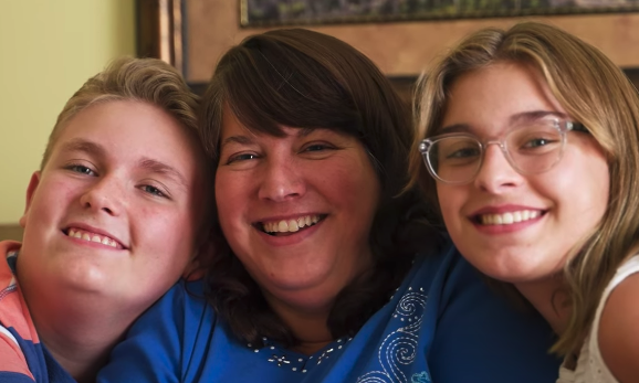 Michelle and her family pose on the couch in this foster care adoption success story